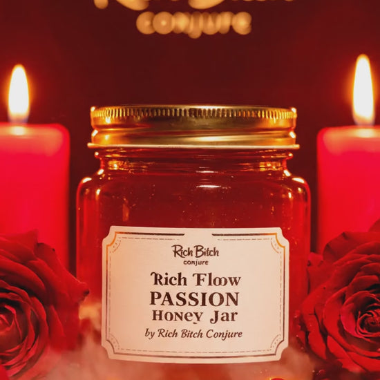 A sensual 4 oz Rich Flow Passion Honey Jar with a gold lid, red roses, and red candle lighting.