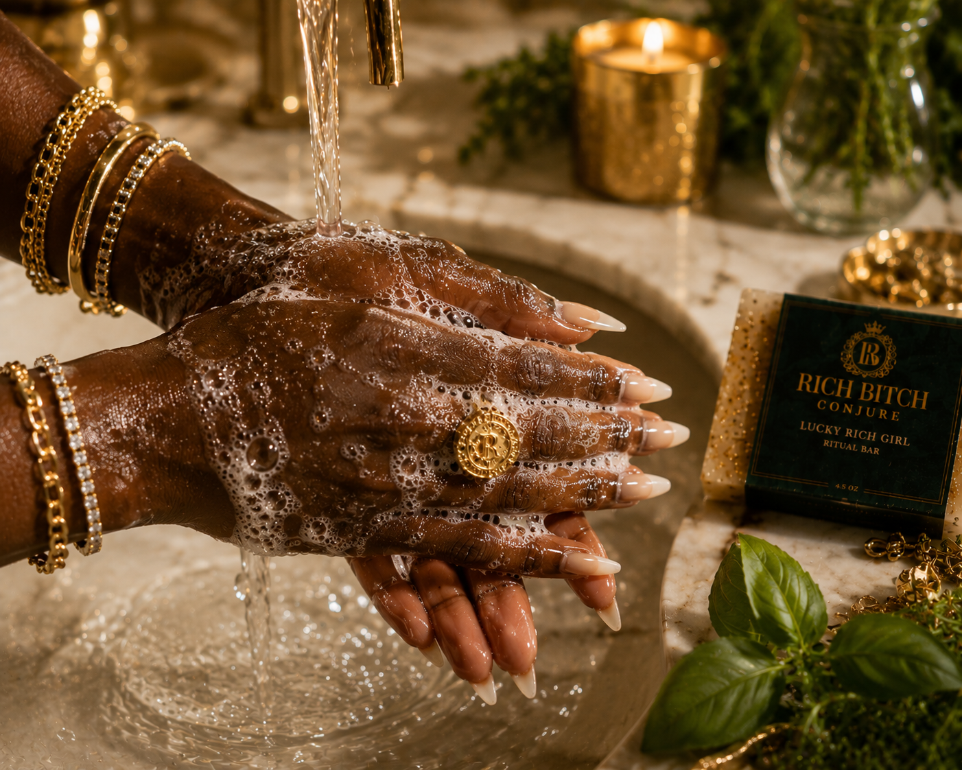 Person washing hands with soap in a sink, wearing gold jewelry, with a decorative bottle labeled 'Rich Bitch' in the background.